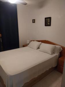 a bedroom with a large bed with white sheets at Apartamento en el centro de zaragoza "EL RUBÍ DEL PILAR" in Zaragoza
