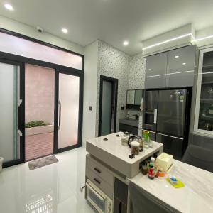 a kitchen with white counters and a large window at PAN House - Homestay Villa in Phan Thiet in Ấp Bình Hưng