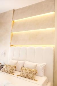 een slaapkamer met een wit bed met kussens bij Kairos Relais in Napels