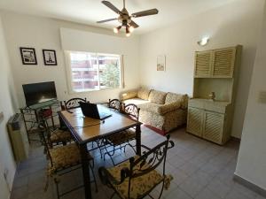 a living room with a table and a couch at Ayres de Pinamar in Pinamar