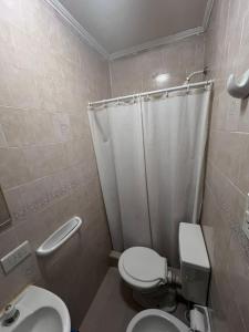 un baño con inodoro y lavabo en Praga Hotel, en Puerto San Julián