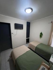 Un dormitorio con dos camas y un televisor de pantalla plana. en Praga Hotel, en Puerto San Julián