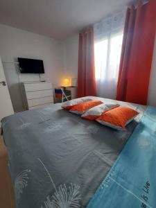 a bedroom with a bed with orange pillows and a television at NEW JASMINe in Tenerife