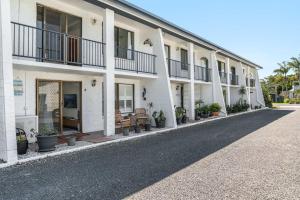 a row of white buildings with potted plants at Iluka Villa 4 in Iluka