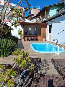 a backyard with a swimming pool and a house at Pousada Makani Kai in Florianópolis