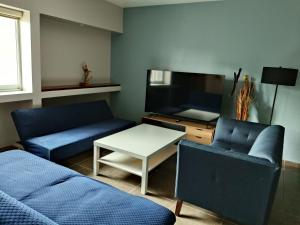 a living room with two blue couches and a tv at NSI Casa Entera en La Piedad in San Juan del Fuerte