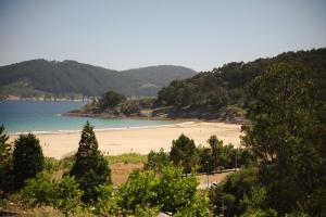 a view of a beach with people in the water at Hórreos de Abrela in O Vicedo