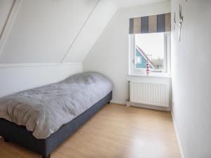 a bedroom with a bed and a window at La Courege in Zonnemaire