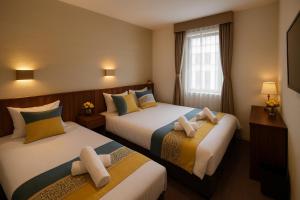 a hotel room with two beds and a window at Plaza In Kanku Hotel in Izumi-Sano