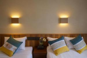 twee bedden in een kamer met twee lampen aan de muur bij Plaza In Kanku Hotel in Izumi-Sano +32 foto's