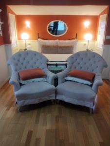 - une chambre avec deux chaises et un lit avec un miroir dans l'établissement Bella Rouge Cottage, à Bright 12 autres photos