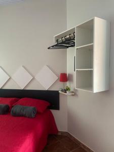 a bedroom with a red bed and a cabinet at Hogar experience in Macapá