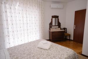 a bedroom with a bed with a mirror and a dresser at Pequeno Refúgio in Braga