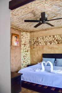 a bedroom with a bed with two swans on it at Habitaciones Colonial Zaci in Valladolid