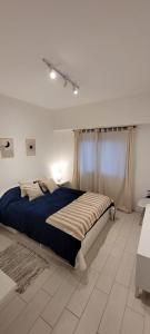 a bedroom with a bed in a white room at Depto 3amb en Torreón del Monje in Mar del Plata