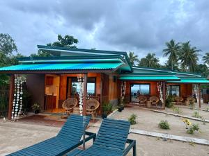 a group of blue chairs in front of a house at Kattegat Beachfront Villa in El Nido