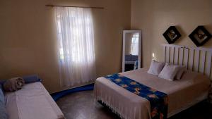 a bedroom with a large bed and a window at Chalé Rosa in Pirenópolis