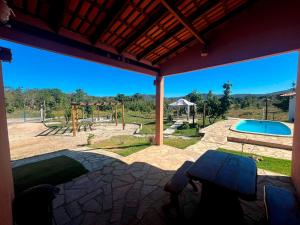 a view of a playground with a pool and a table at Chalé Rosa in Pirenópolis