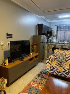 a living room with a flat screen tv and a couch at The Janda Panda in Kampala