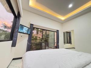 Un dormitorio con una cama y una ventana grande. en Hostel Labuan ORA, en Labuan Bajo 4 fotos más