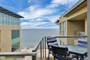 グレネルグにあるSeaside Apartment with Shared Gym & Saunaのバルコニー(ビーチのテーブルと椅子付)