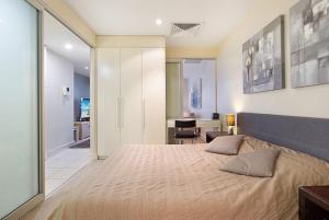 グレネルグにあるSeaside Apartment with Shared Gym & Saunaの大きなベッドと机のある寝室