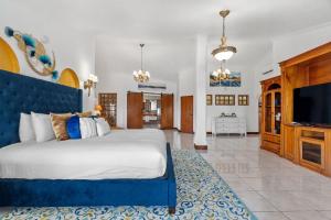 a bedroom with a large bed and a flat screen tv at Casa Blue Laguna I Tropical Scape with Ocean View in Las Croabas