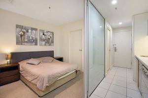 グレネルグにあるSeaside Apartment with Shared Gym & Saunaのベッドルーム1室(ベッド1台、ウォークインシャワー付) +8枚の写真