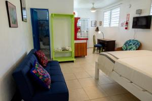 a bedroom with a bed and a couch and a kitchen at Studio 1 Tinima with Garden access in Vieques