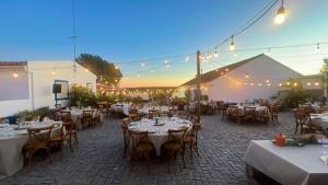 an outdoor patio with tables and chairs and lights at Monte da Oliveirinha in Évora