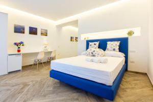 a bedroom with a blue and white bed and a desk at Il Golfo Suites in Sorrento