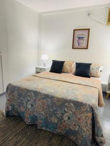 a bedroom with a large bed with a floral bedspread at Loft Santorini II in Manaus