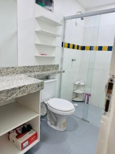 a bathroom with a toilet and a glass shower at Loft Santorini II in Manaus