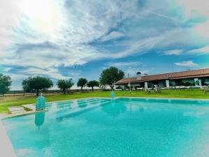 a large blue swimming pool with a building in the background at Monte da Oliveirinha in Évora