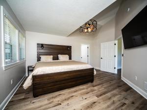 a bedroom with a large bed and a flat screen tv at MT House Luxury Private Estate Experience 5 Acres 20 Min KCI Downtown KC in Liberty +26 photos