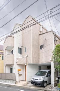 ein Gebäude mit einem davor geparkten Auto in der Unterkunft Familia Kamata 2 in Tokio