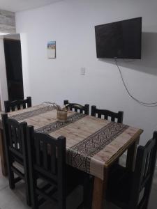 un tavolo in legno con sedie e una televisione appesa a un muro di Mate host 2 a Córdoba