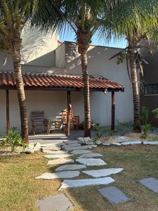 a patio with palm trees in front of a house at Recanto Tarumã in Tangara da Serra