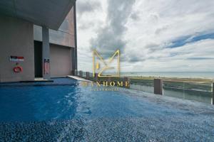 a swimming pool on the side of a building with the ocean at Maxhome Elite at Imperio Melaka in Malacca