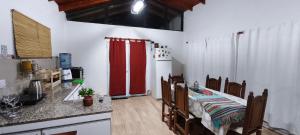 a kitchen with a table and a red refrigerator at Casita de campo con piscina in La Punta