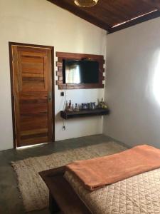 une chambre avec un lit, une fenêtre et une télévision dans l'établissement Casa Pipa Boulevard, à Tibau do Sul