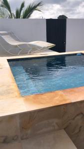 une piscine avec une chaise longue à côté dans l'établissement Casa Pipa Boulevard, à Tibau do Sul