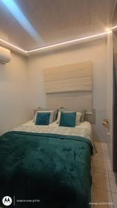 a bedroom with a large bed with blue pillows at Casa SUPER COP in Ananindeua