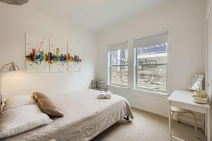 a bedroom with a bed and a desk and a window at SoCo Haven - Stylish Stay - Sleeps 8 & Wifi in Austin