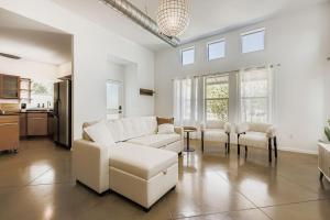 a living room with a white couch and chairs at SoCo Haven - Stylish Stay - Sleeps 8 & Wifi in Austin