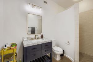 a bathroom with a sink and a toilet and a mirror at SoCo Haven - Stylish Stay - Sleeps 8 & Wifi in Austin +18 photos