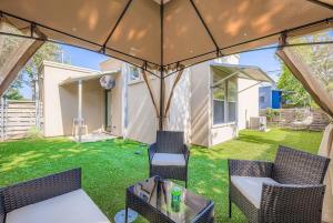 a patio with chairs and a table and an umbrella at SoCo Haven - Stylish Stay - Sleeps 8 & Wifi in Austin