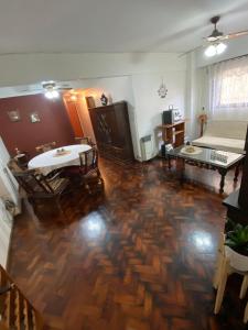 a living room with a wooden floor and a bed at Departamento sobre Boulevard Oroño in Rosario