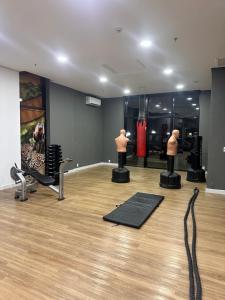 a room with a gym with two mannequins in it at Flat Tropical in Manaus