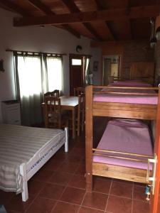 een kamer met drie stapelbedden en een tafel bij En Esta Tierra in Villa Gesell